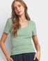 Woman wearing a green t-shirt against a plain background