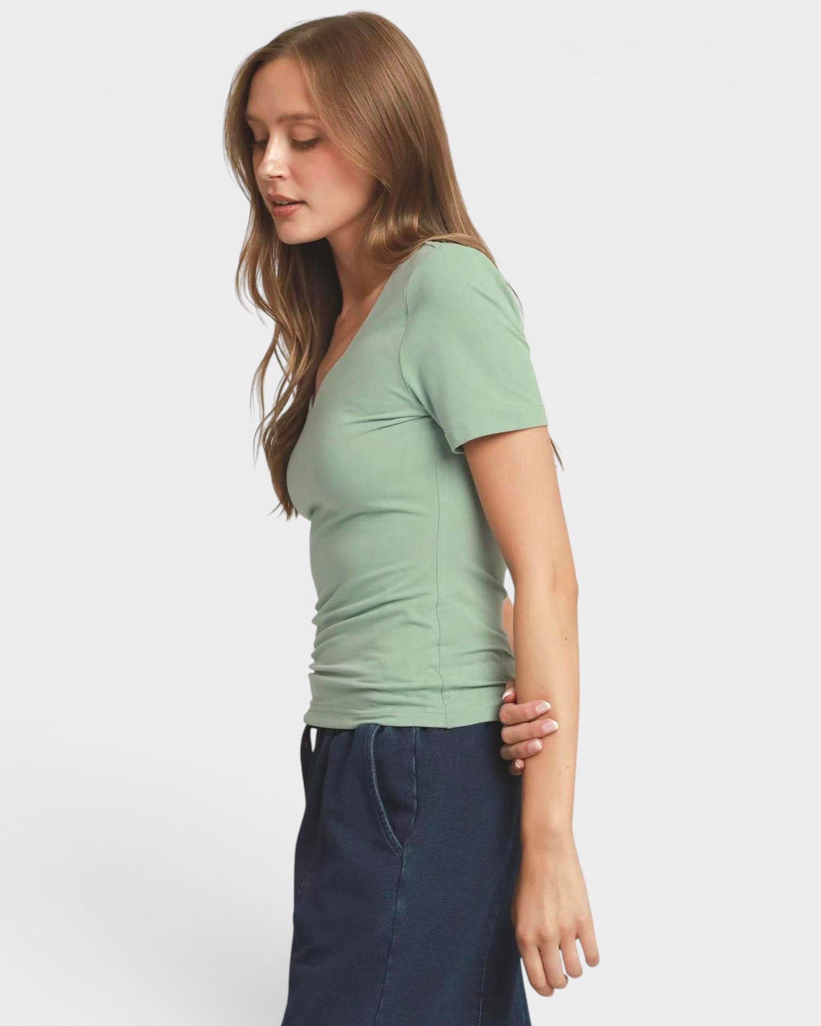 Woman wearing a green t-shirt against a plain background