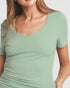 Woman wearing a green t-shirt against a plain background