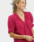 Woman wearing a pink blouse with ruffled details on a white background