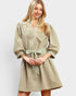 Woman wearing a beige dress with a belt on a white background