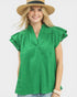 Woman wearing a green blouse with ruffled sleeves and a straw hat on a white background