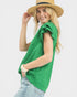 Woman wearing a green sleeveless top and straw hat on a white background