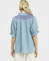 Woman wearing a light blue blouse with intricate back design on a white background