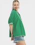 Woman wearing a green mesh top with white trim on a white background