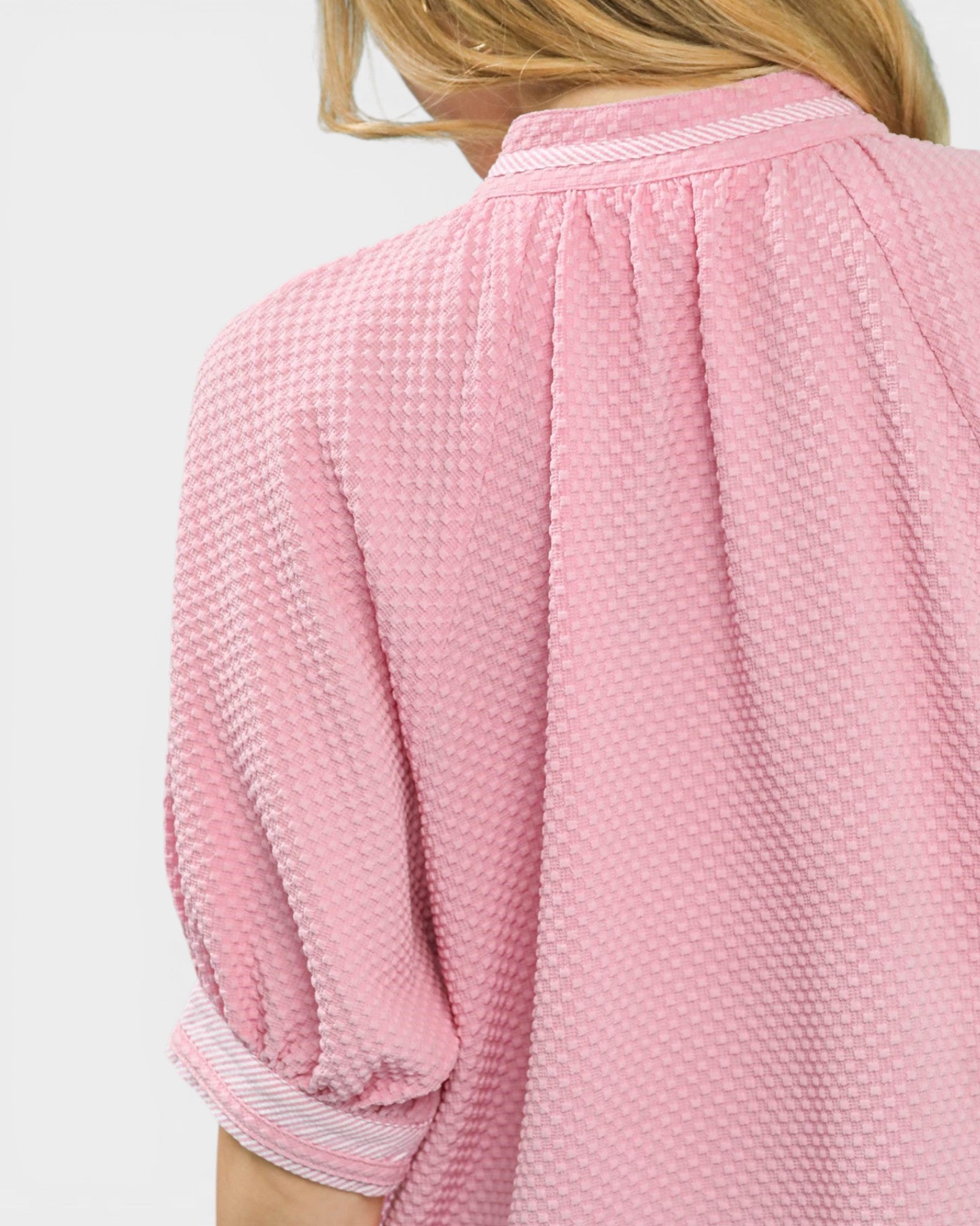 Close-up of a textured pink garment with a white background