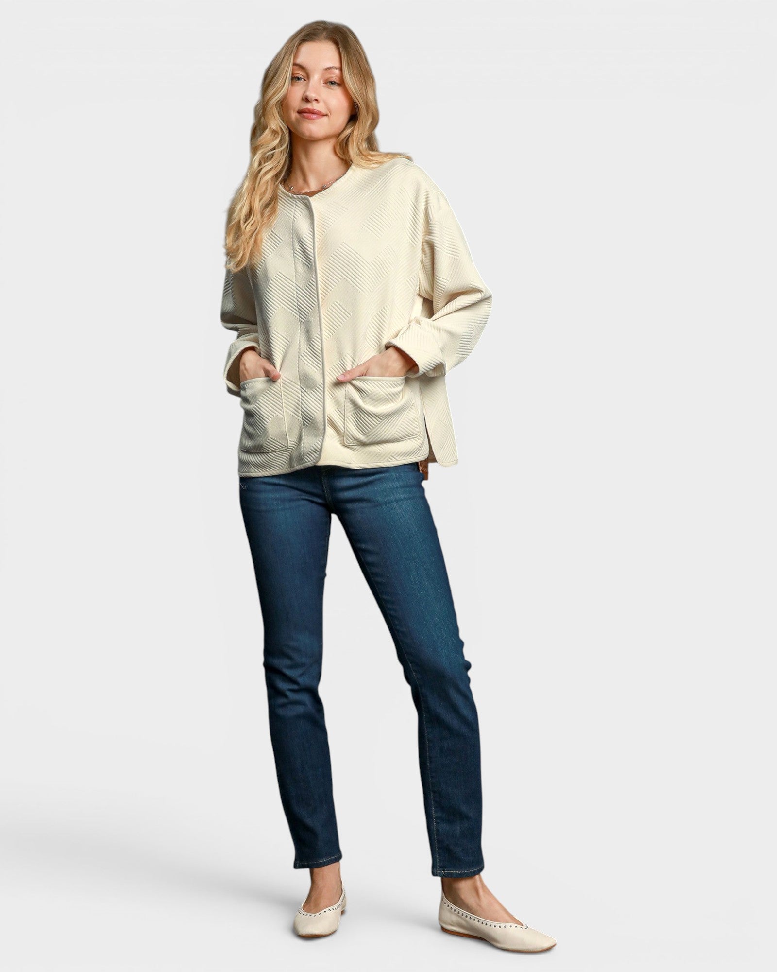Woman wearing a beige jacket and blue jeans on a white background