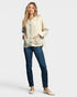 Woman wearing a beige jacket and blue jeans on a white background