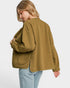 Woman wearing a green jacket and light blue jeans on a white background