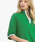 Woman wearing a green dress with white trim on a white background