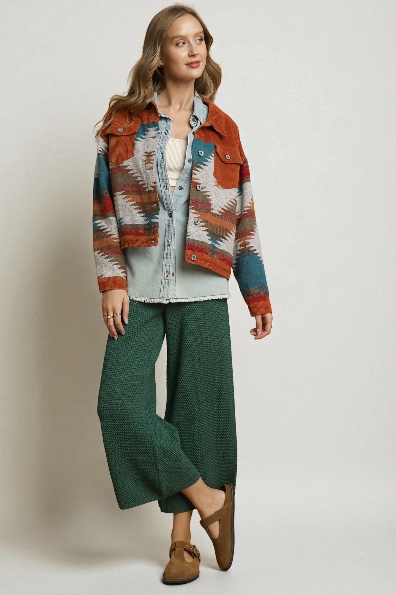 Woman wearing a patterned jacket with a neutral background