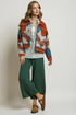 Woman wearing a patterned jacket with a neutral background