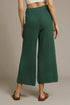 Green textured wide-leg pants worn by a person on a beige background