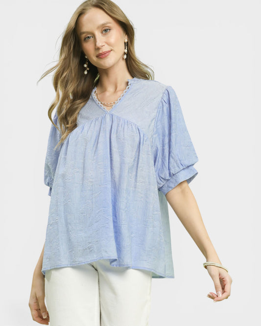 Woman wearing a light blue blouse with a white background