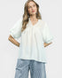 Woman wearing a light blue blouse and striped pants on a white background