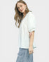 Woman wearing a white blouse and striped pants on a light gray background