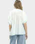 Woman wearing a white blouse and striped pants on a plain background
