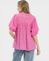 Person wearing a pink blouse with puff sleeves on a white background