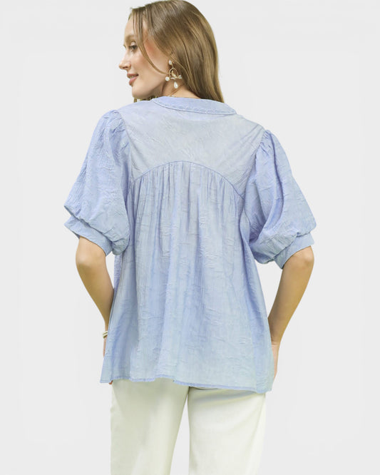 Woman wearing a light blue striped shirt on a white background