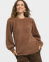 Woman wearing a brown sweater with leopard print pants on a white background