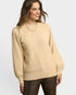 Woman wearing a beige sweater on a plain background