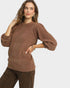 Woman wearing a brown sweater with a plain background