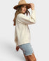Woman wearing a cream sweater and denim shorts with a beige hat on a white background