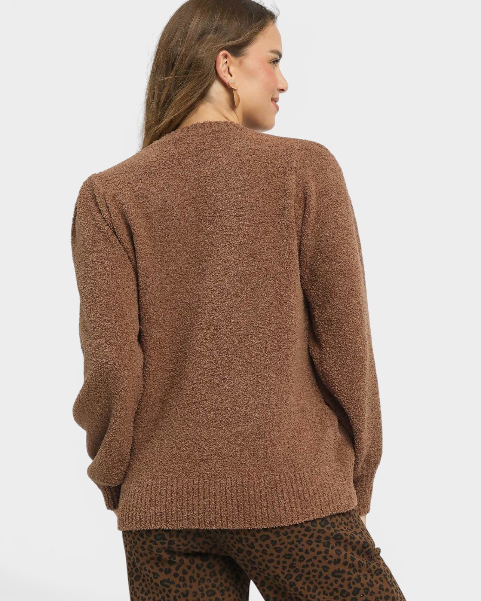 Woman wearing a brown sweater on a white background