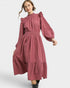 Woman wearing a pink dress with long sleeves on a white background