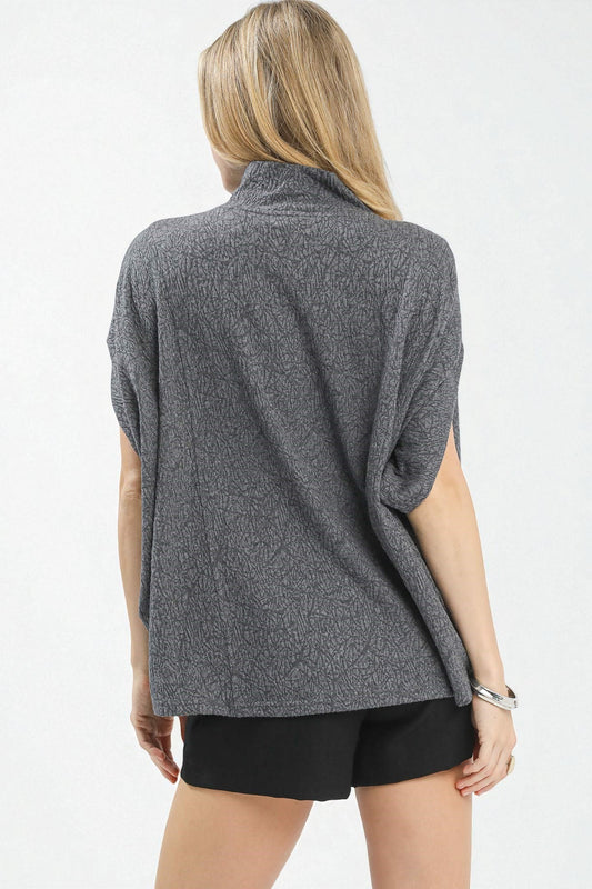 Person wearing a gray sleeveless top and black shorts on a white background