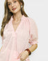 Woman wearing a light pink dress with a plain background