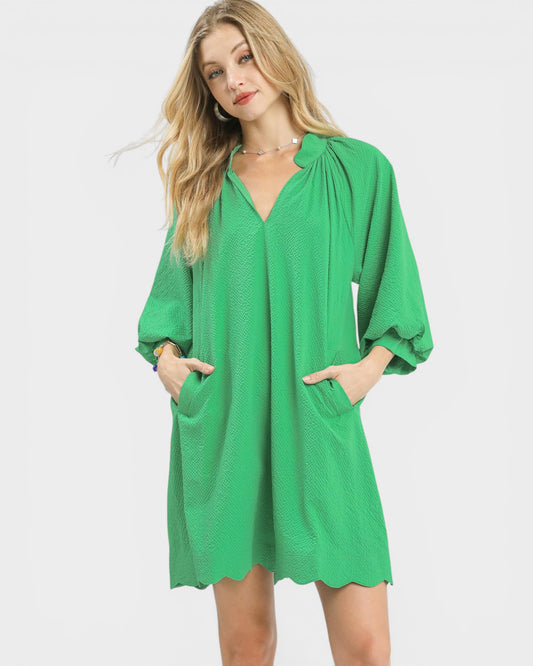 Woman wearing a green dress with a plain background