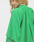 Green textured garment worn by a person on a white background