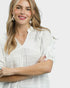 Woman wearing a white blouse with a plain background