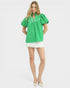 Woman wearing a green blouse and white skirt on a white background