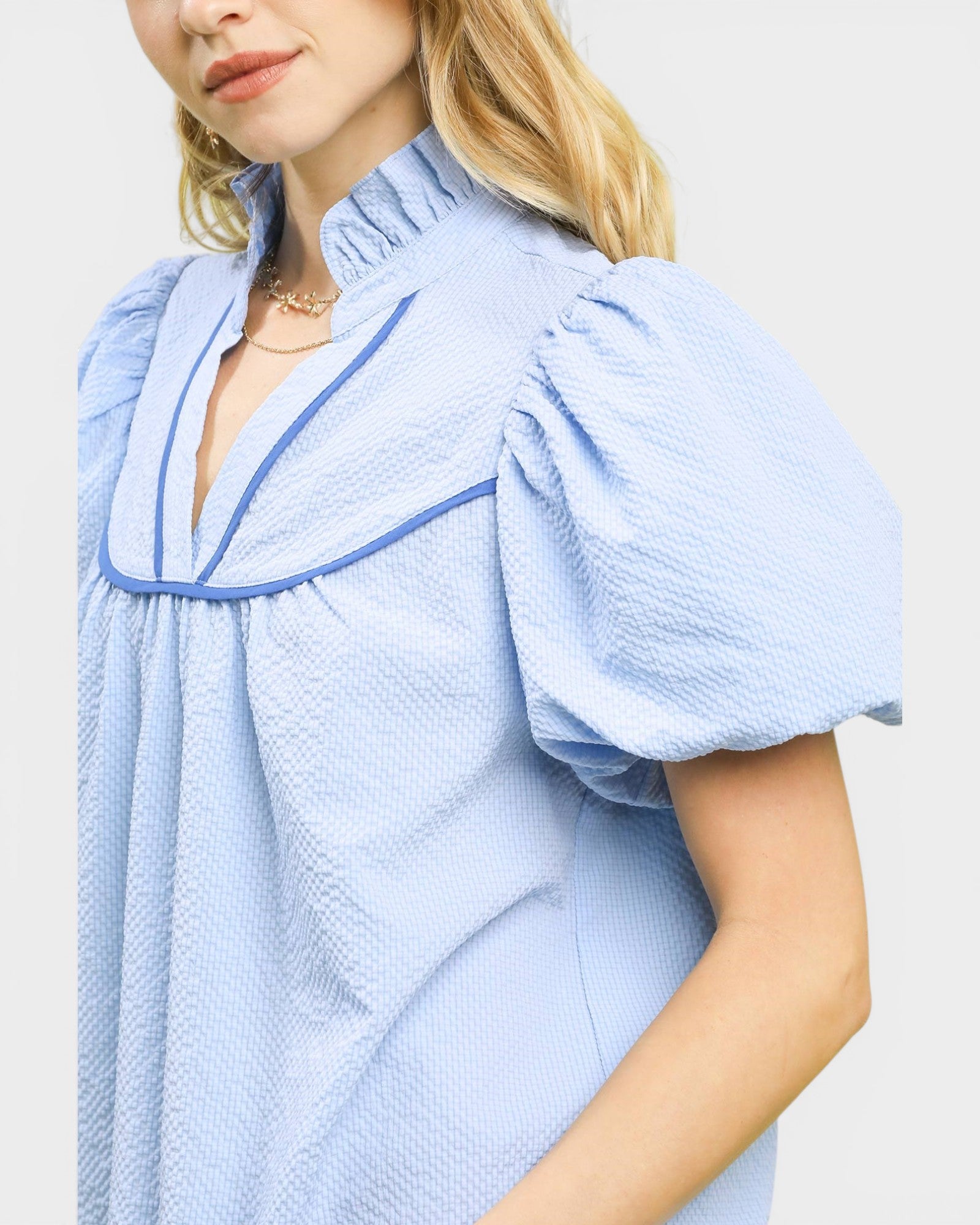 Light blue dress with puffed sleeves worn by a person on a white background