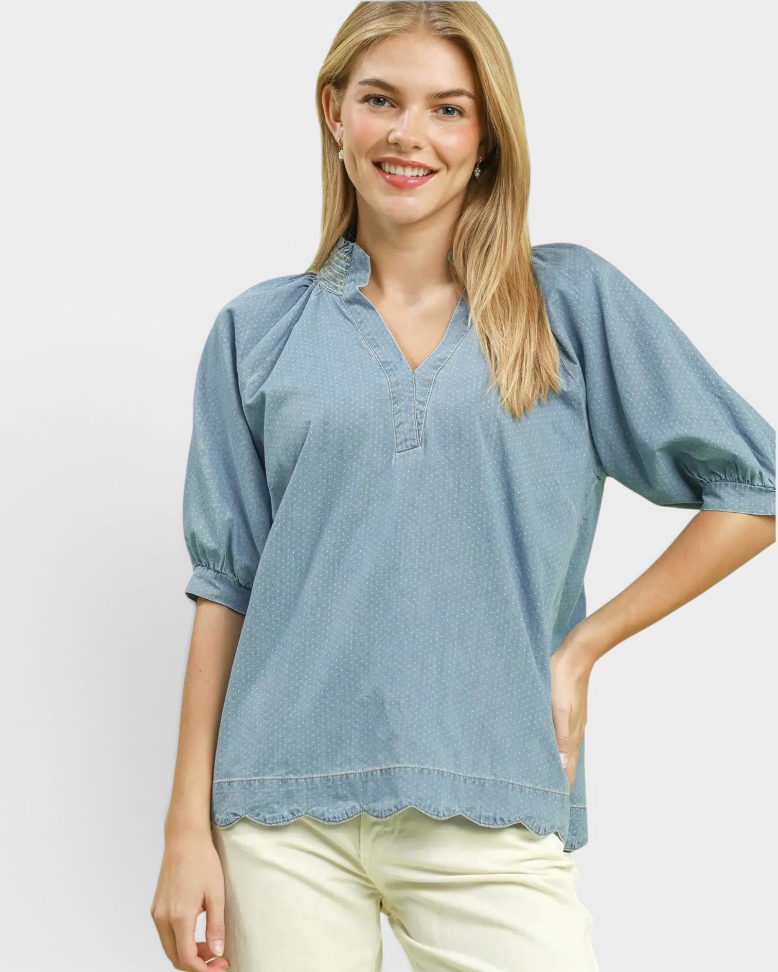 Woman wearing a light blue blouse with a plain background