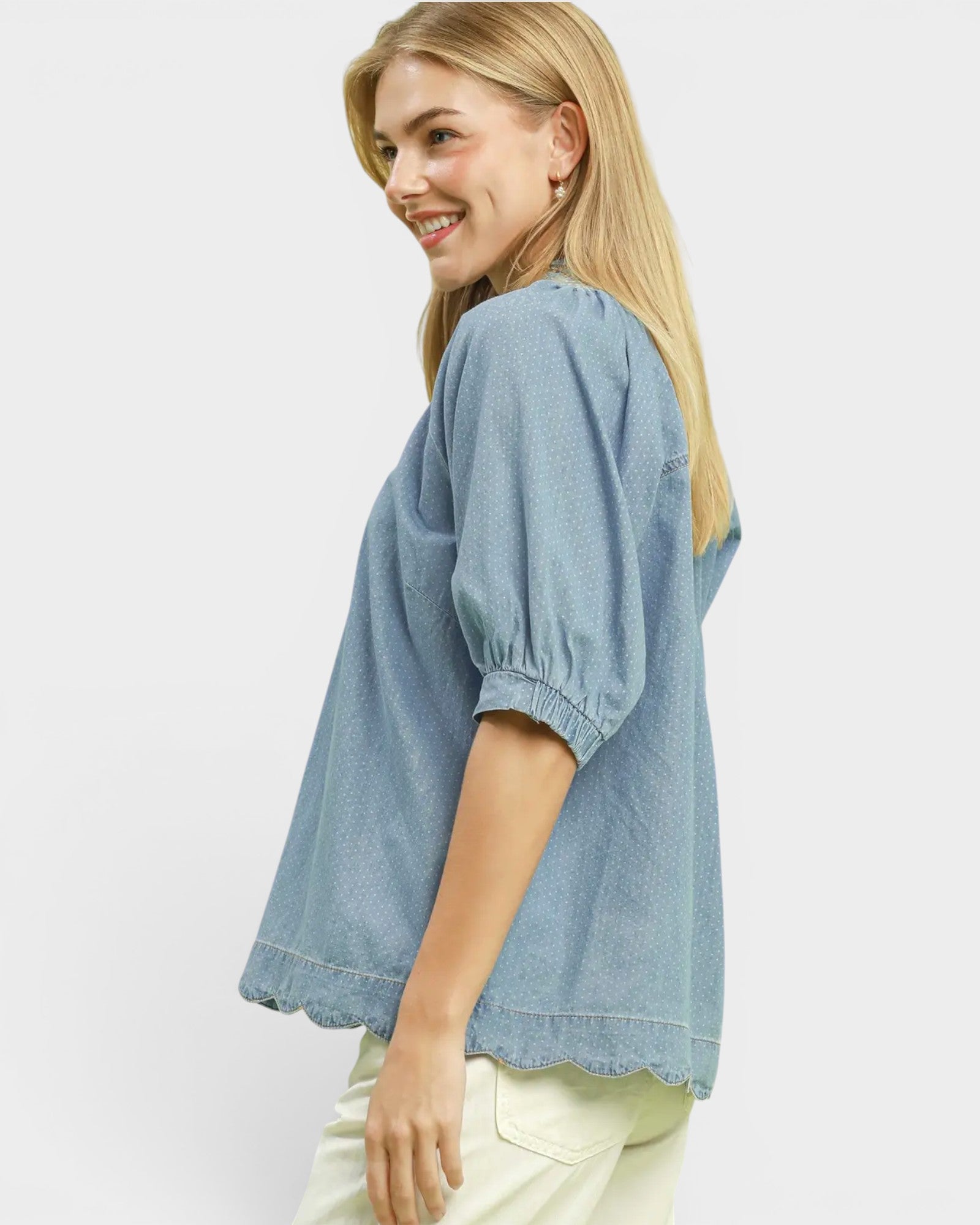 Woman wearing a light blue denim shirt on a white background