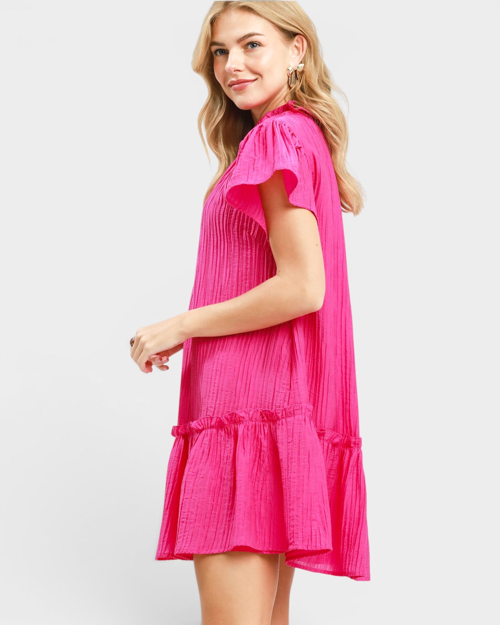 Woman wearing a bright pink dress on a white background