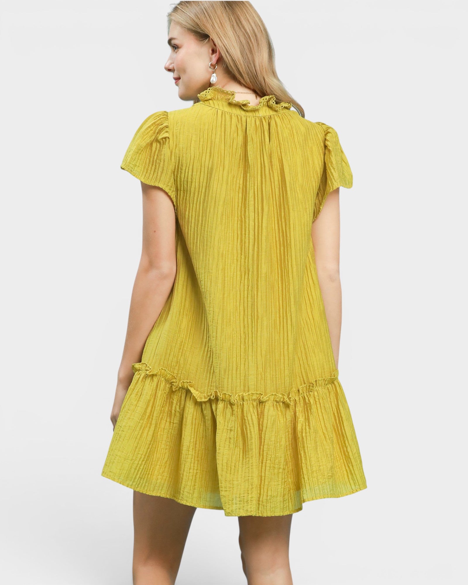 Yellow dress worn by a person on a white background