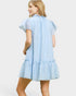 Woman wearing a light blue dress with ruffled details on a white background