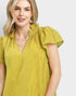 Woman wearing a yellow blouse with ruffled sleeves on a white background