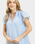 Woman wearing a light blue ruffled blouse on a white background