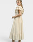 Woman wearing a beige dress with ruffled sleeves on a white background