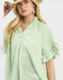 Woman wearing a light green textured dress with a white background