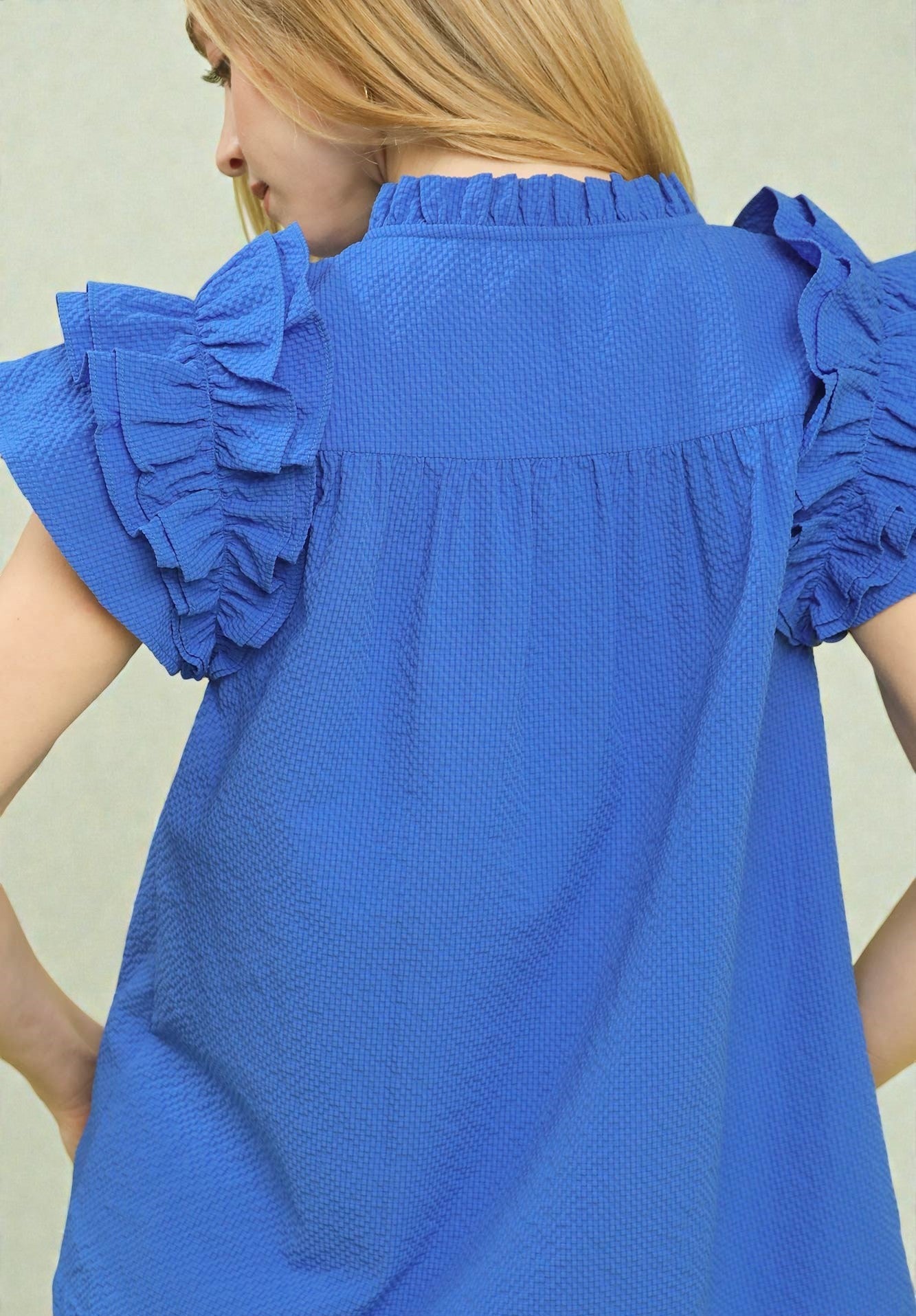 Blue blouse with ruffled sleeves on a plain background