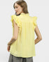 Woman wearing a yellow blouse with ruffled sleeves on a white background