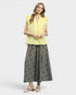 Woman wearing a yellow top and gray skirt on a white background