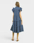 Woman wearing a blue tiered dress on a white background