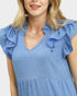 Woman wearing a blue dress with ruffled sleeves on a white background